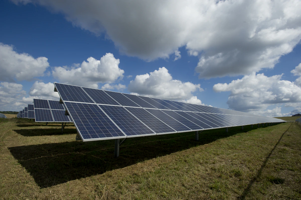 A solar consultant on a rooftop site visit at sunset